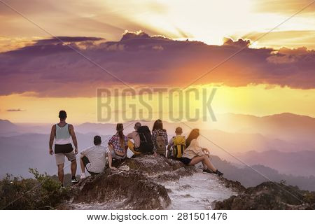 Big Group Of Friends Stands On Mountain Top And Looks At Beautiful Sunset. Travel With Friends Conce