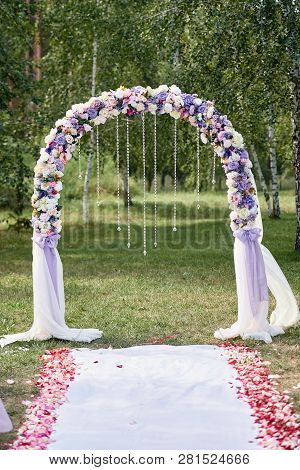 Place For Wedding Ceremony. Wedding Arch Decorated With Cloth And Flowers And Chairs On Each Side Of