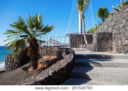 Puerto Del Carmen Beach In Lanzarote, Canary Islands, Spain. Blue Sea, Palm Trees, Promenade, Select