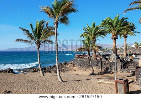 Puerto Del Carmen Beach In Lanzarote, Canary Islands, Spain. Blue Sea, Palm Trees, Selective Focus