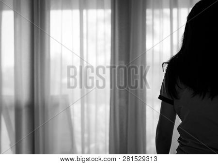 Rear View Of Sad Adult Asian Woman Sit On Bed In Bedroom. Stressed And Depressed Young Woman. Despai