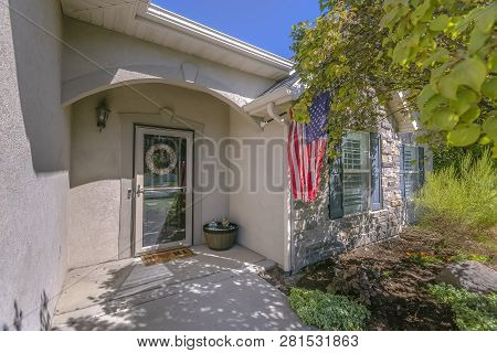 Facade Of Home With An American Flag On The Wall