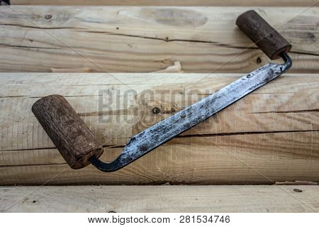 Antique Carpentry Tool Folding Drawknife On The Background Of Wooden Logs