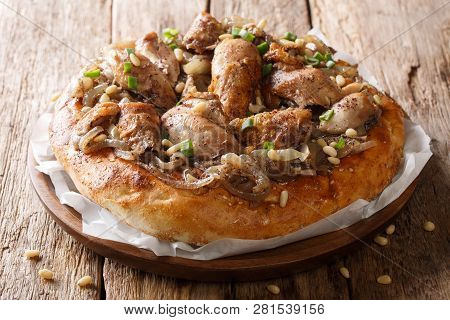 Middle Eastern Meal Of Chicken With Sumac, Pine Nuts And Onions On A Flat Bread Closeup. Horizontal