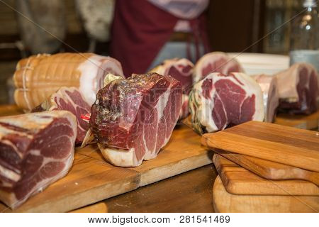 Pieces Of Raw Ham And Culatello On A Wooden Chopping Board.