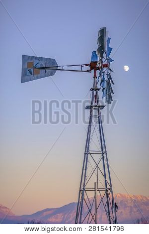 Windpump Against Mountain And Sky With Moon