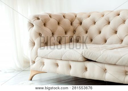 Fragment Of A Beige Sofa With Buttons