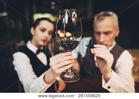 Sommelier Is Studying Sediments In Glass Of Wine.waiter Holds Glass Of Red Wine. Wine Tasting. Check