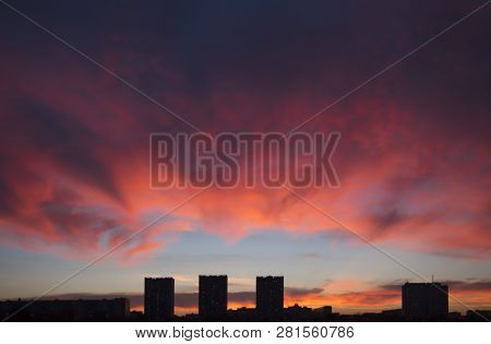 Mystical Purplish Red Sunset Over The Dark Silhouette Of City. Incredibly Beautiful Cloudscape In Su