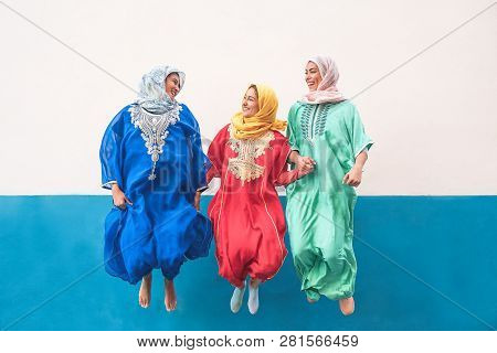 Happy Muslim Women Jumping Together Outdoor - Arabian Teen Girls Having Fun In The City - Concept Of
