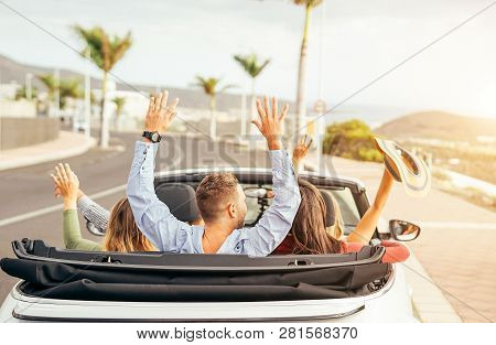 Happy Friends Having Fun In Convertible Car At Sunset In Vacation - Young People Making Party And Da