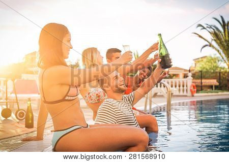 Group Of Happy Friends Making A Pool Party At Sunset - Young People Laughing And Having Fun Drinking