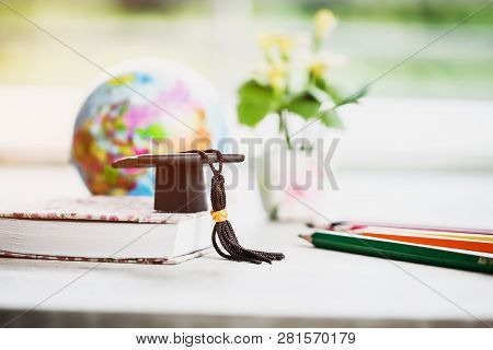 Graduate Or Education Knowledge Learning Study Abroad Concept : Graduation Cap On Book With Blur Of 