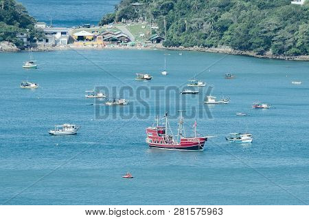 Bombinhas - Sc, Brazil - December 18, 2018: Touristic Red Ship Sailing In Front Of The Praia Da Sepu