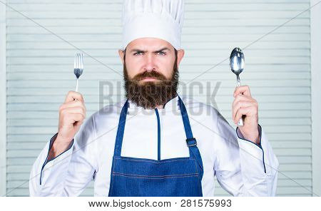 Time To Try Taste. Chef Serious Face Hold Spoon And Fork. Man Handsome With Beard Holds Kitchenware 