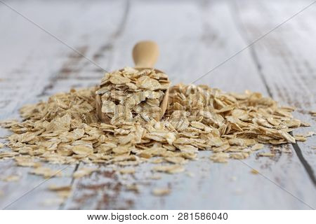 Dried Oats Or Oatmeal In Spoon On The Wood Table. Its Are A Nutrient-rich Food Associated With Prote
