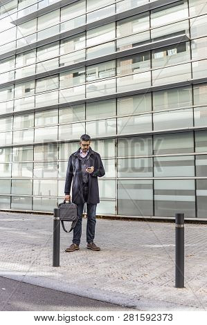Middle Aged Man With A Briefcase And A Phone On The Street