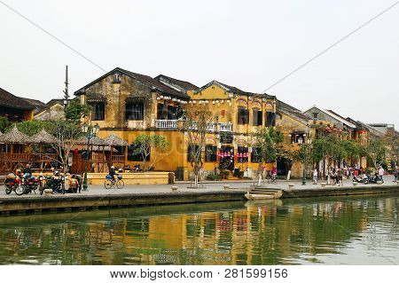 Hoi An, Vietnam - February 12, 2018: View On The Embankment Of Thu Bon River With Yellow Buildings. 