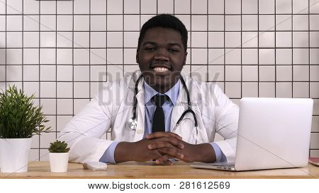 Young Doctor At His Working Place Smiling.