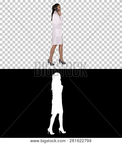 Female Dr Smiles While Talking On The Phone, Walking, Alpha Channel