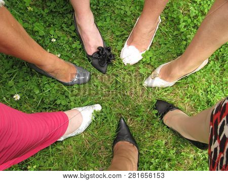 Shoes In A Circle.  A Group Of Formally Dressed Ladies In A Circle With One Shoed Foot Forward.