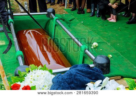 People At Funeral Putting Down The Coffin At A Funeral