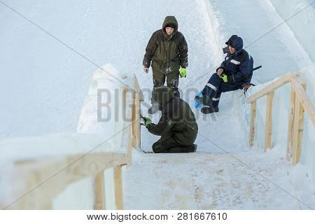Three Workers At The Installation Of The Ice Town