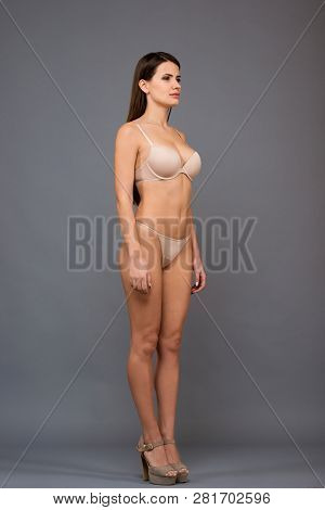 Full Length Portrait Of Beautiful Brunette Women With A Slim Figure In Light Underclothing. Model Sn