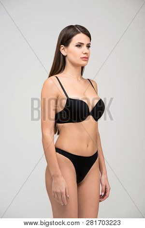 Three-quarter Portrait Of Beautiful Brunette Women With A Slim Figure In Black Bra And Thong. Model 