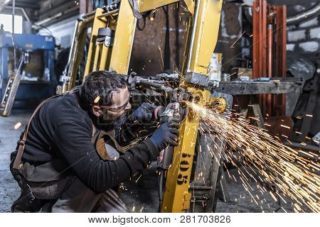 Young Worker With A Sander Machine In A Factory