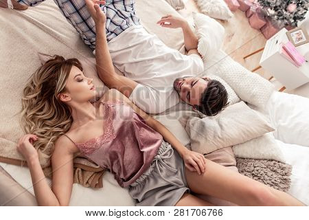 Pretty Long-haired Blond Woman In Satin Home Clothes Looking Happy