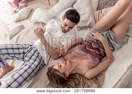 Pretty Long-haired Blond Woman And Her Dark-haired Husband Looking Thoughtful