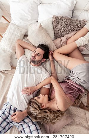 Dark-haired Handsome Young Man In A White T-shirt Putting His Head On His Wifes Belly