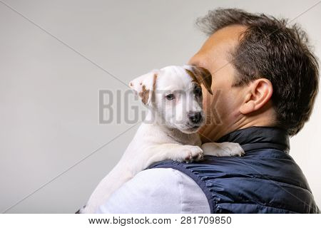 Horizontal Portrait Of Handsome Cheerful Man Holds Jack Russell Terrirer, Has Glad Expression
