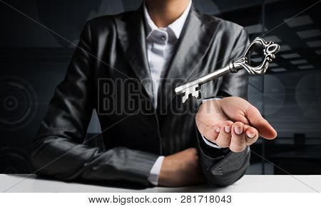 Cropped Image Of Businessman In Suit Keeping Big Key In Hand With Office View On Background.