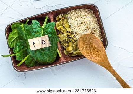 Spinach, Pumpkin Seeds, Sesame And One Wood Spoon On A White Background. Microelement Fe. Close-up.