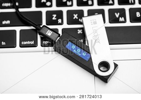 UKRAINE, ROVNO - ON JANUARY 29: Ledger Wallet On Laptop for cryptocurrency on a wood background