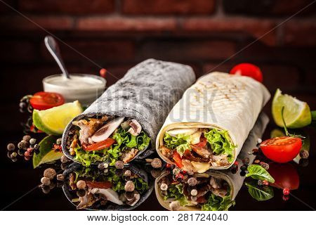Two Burrito, Black And White Lavash With Chicken, Mushrooms, Salad, Cherry Tomatoes, Lime, And Salsa