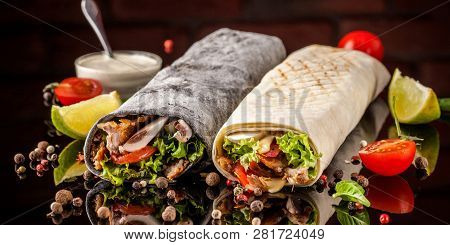 Two Burrito, Black And White Lavash With Chicken, Mushrooms, Salad, Cherry Tomatoes, Lime, And Salsa
