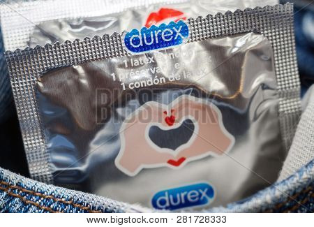 Tyumen, Russia - February 01, 2019: Durex Condom In Hand On Blue Background Close-up. Used To Preven