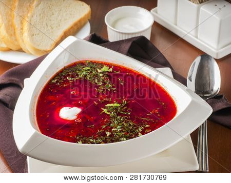 Ucrainian Russian Traditional Beetroot Soup - Borsch In Triangular White Plate On Dark Brown Wooden 
