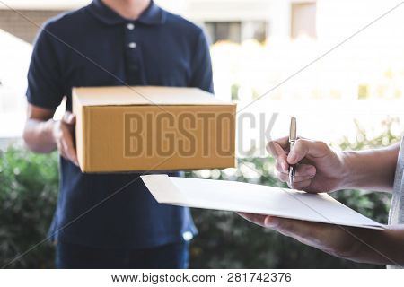 Delivery Mail Man Giving Parcel Box To Recipient, Young Man Signing Receipt Of Delivery Package From