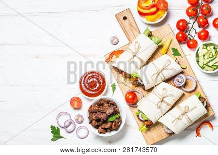 Burritos Tortilla Wraps With Beef And Vegetables On White Wooden Table.  Traditional Latin American 