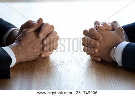 Clasped Hands Of Two Businessmen Negotiators Opponents Opposite On Table