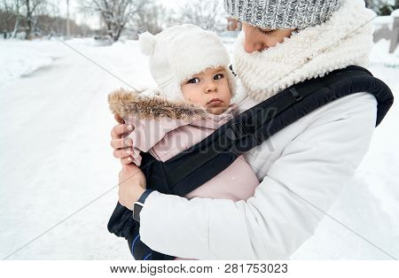 Little Baby Girl And Her Mother Walking Outside In Winter Mother Is Holding Her Baby Babywearing In 