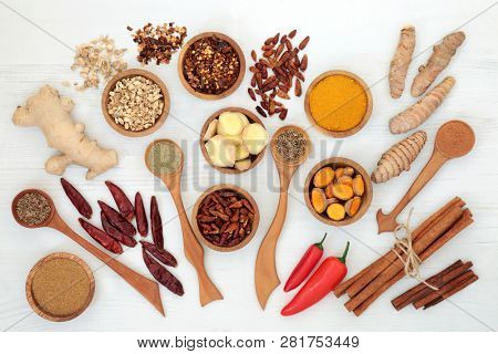 Spices for weight loss with turmeric, cumin, ginger, chilli, cinnamon and gymnema sylvestre used to suppress appetite. Top view on rustic wood background.