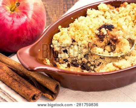 Homemade Apple Cramble Cake With Fresh Apples And Cinnamon Sticks On Rustic Dark Wooden Background