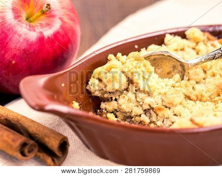 Homemade Apple Cramble Cake With Fresh Apples And Cinnamon Sticks On Rustic Dark Wooden Background