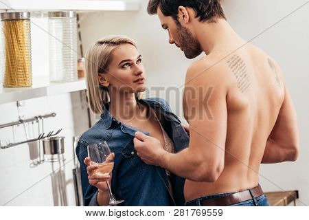 Selective Focus Of Attractive Girlfriend And Handsome Boyfriend Holding Wine Glass And Hugging At Ki