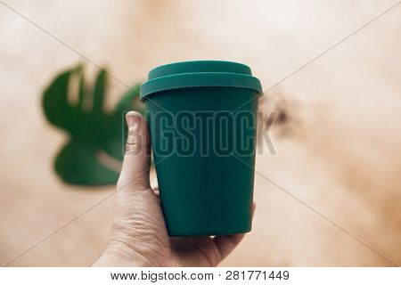 Ban Single Use Plastic. Hand Holding Eco Reusable Coffee Cup On Wooden Background. Coffee Cup From B